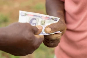 Two People Exchanging Kenya Currency